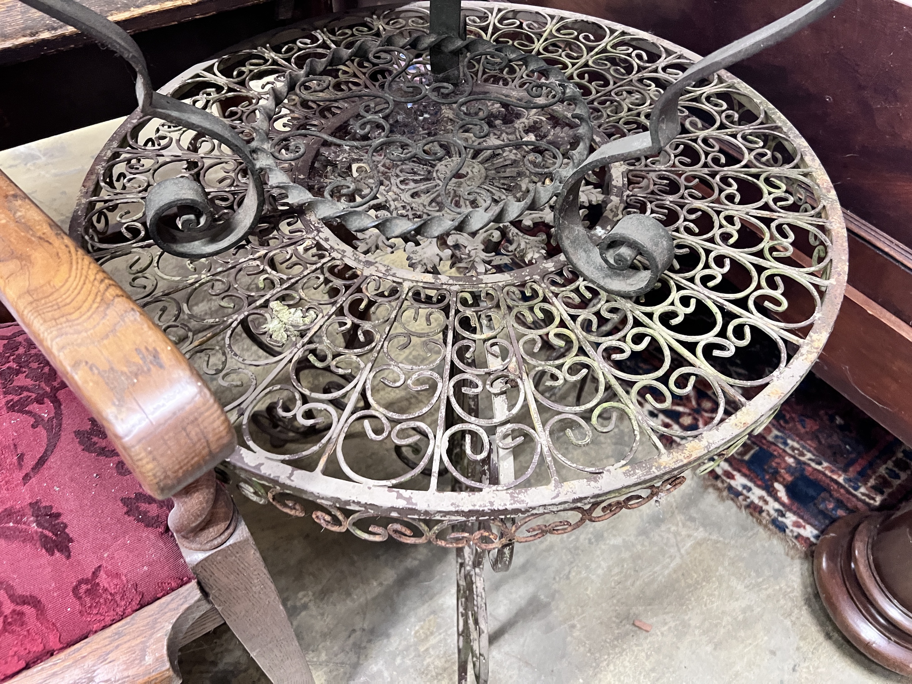 A wrought iron garden table, diameter 69cm and a similar low table with mirrored top, diameter 63cm